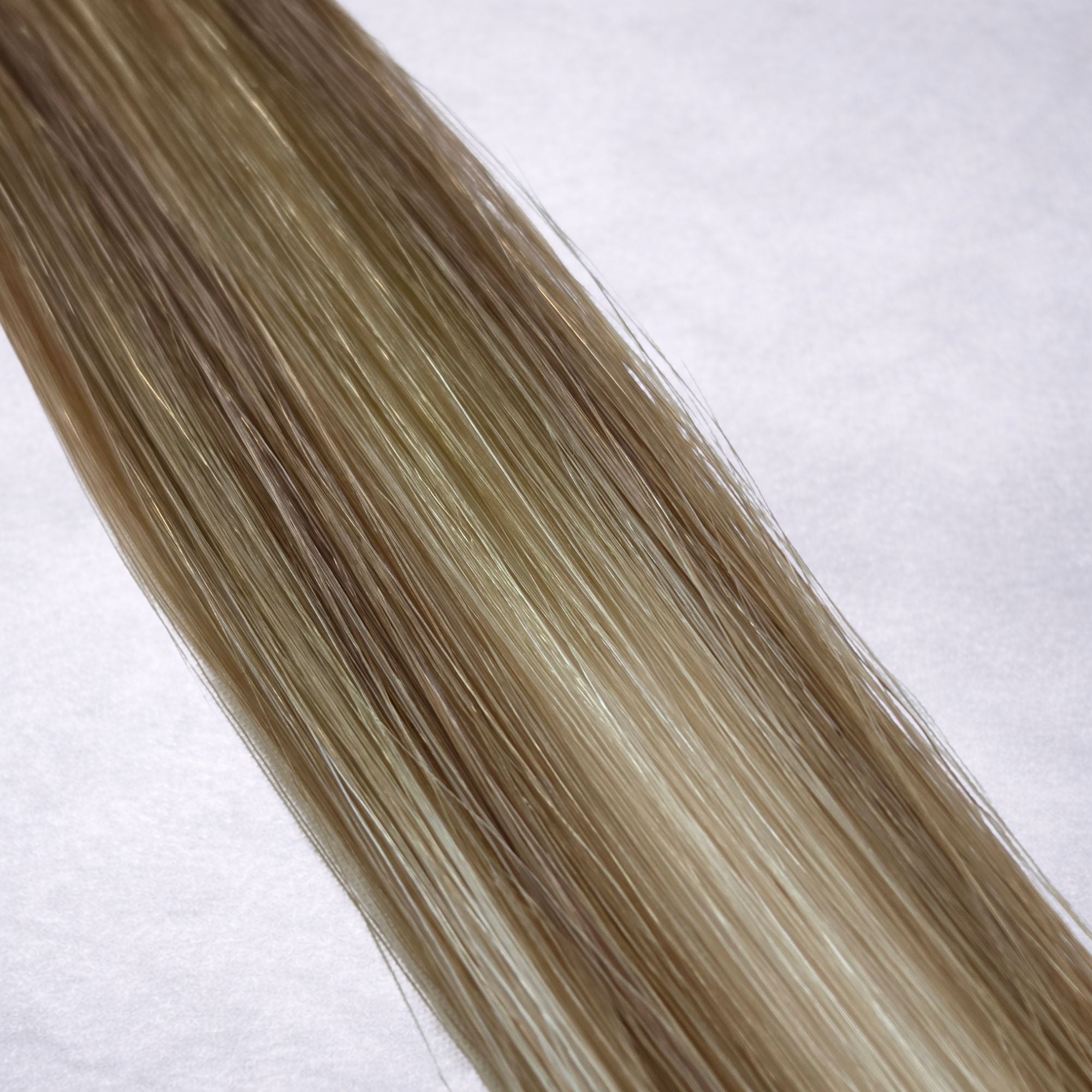 Studio Collection shade swatch in Champagne Bronde #B9A/60A, featuring a dimensional blend of soft fawn brunette and cool oatmilk blonde tones with creamy champagne bronde ribboned highlights, a silky finish, and natural shine.