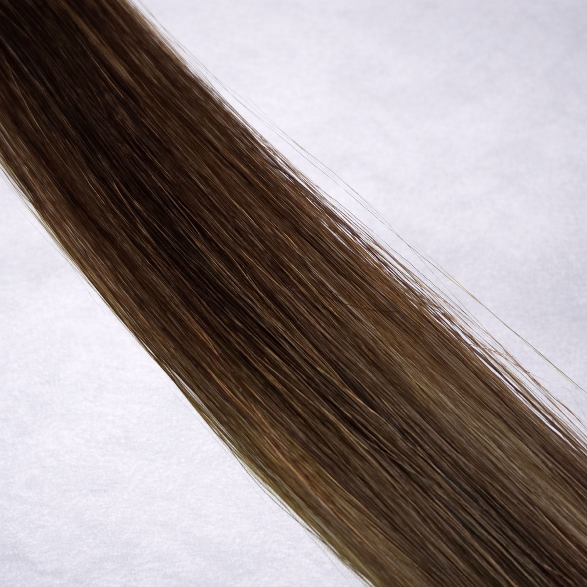 Luxury Remy human hair extension shade swatch in Chocolate #4, featuring a rich warm brown tone with glossy depth, a silky finish, and natural shine.
