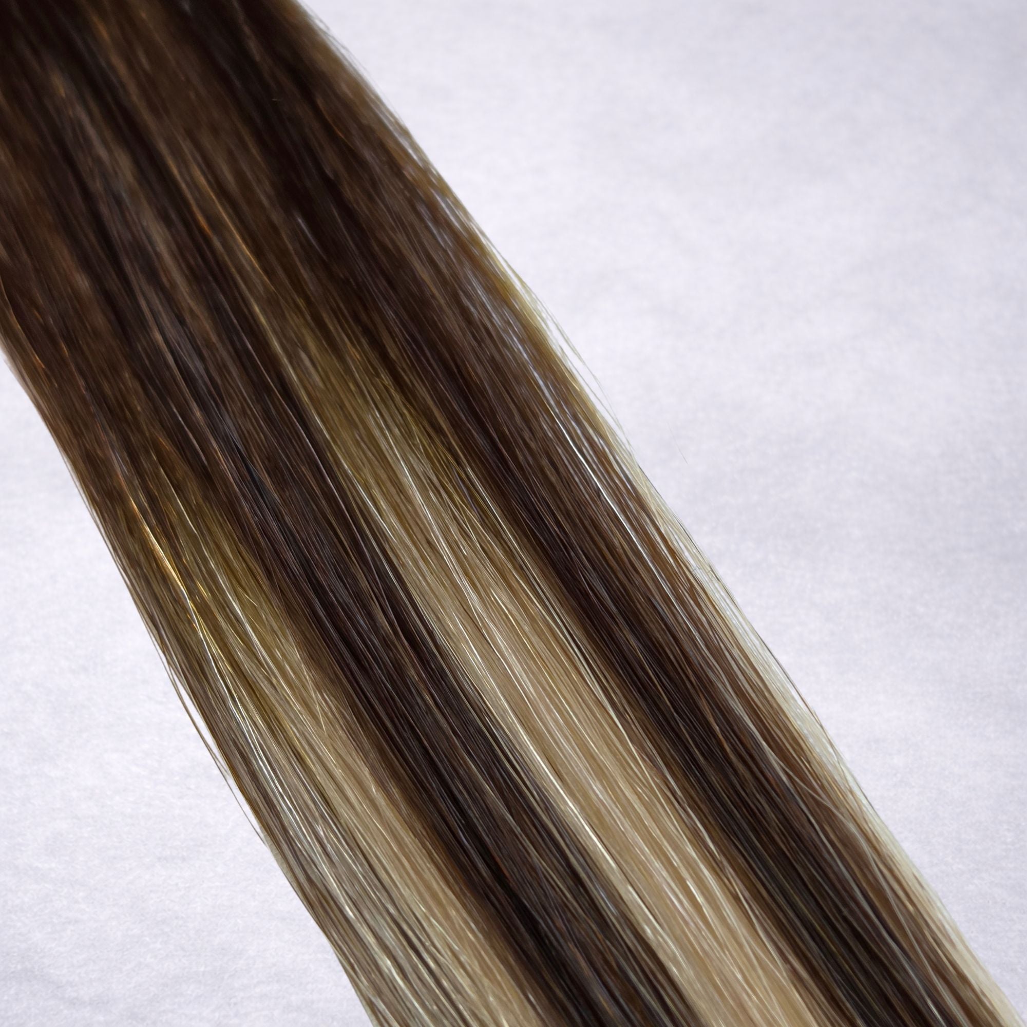Studio Collection luxury Remy human hair extension shade swatch in Chocolate Ash Blonde T4P4/16A, featuring a dimensional blend of rich chocolate brown and cool ash blonde tones with soft contrast, creating a natural multi-tonal finish with silky texture and healthy shine.