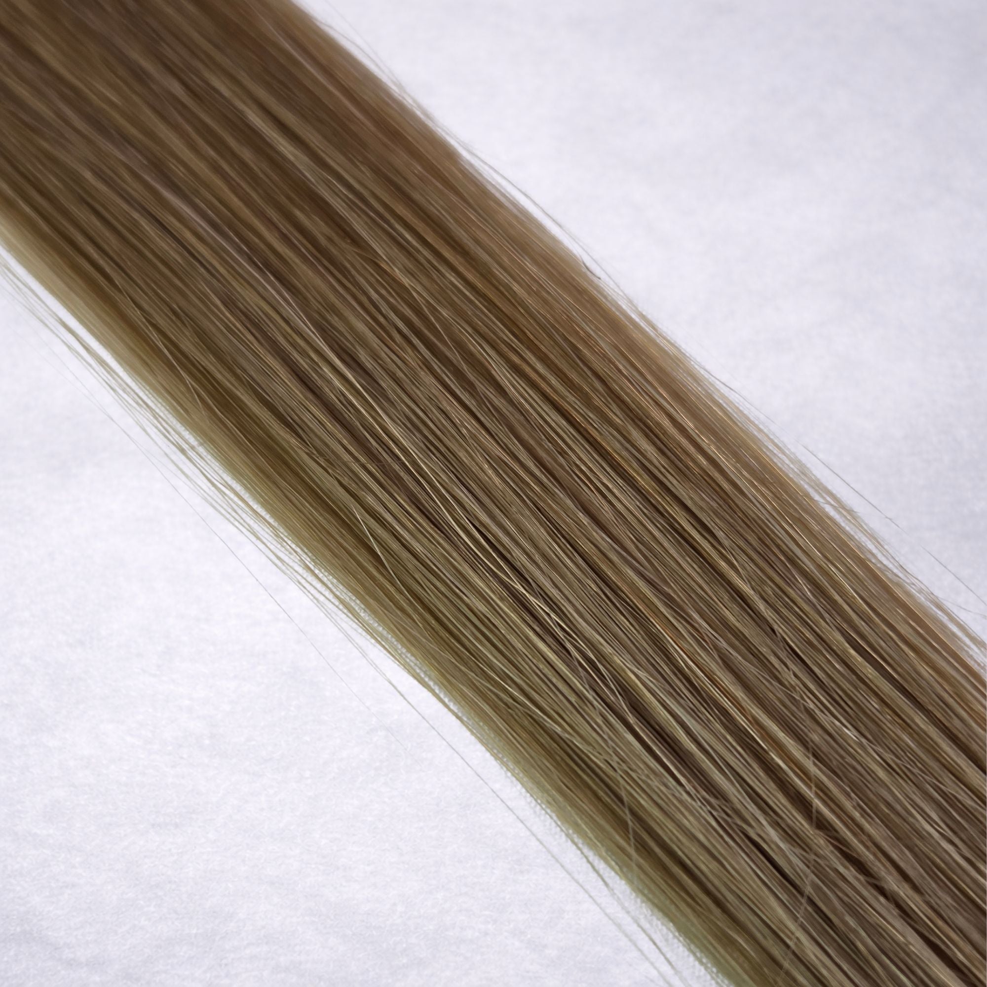 Luxury Remy human hair extension shade swatch in Fawn #9A from the Remalisse Studio Collection, featuring a soft cool blonde tone with muted ash-beige undertones, natural dimension, a silky finish, and natural shine.