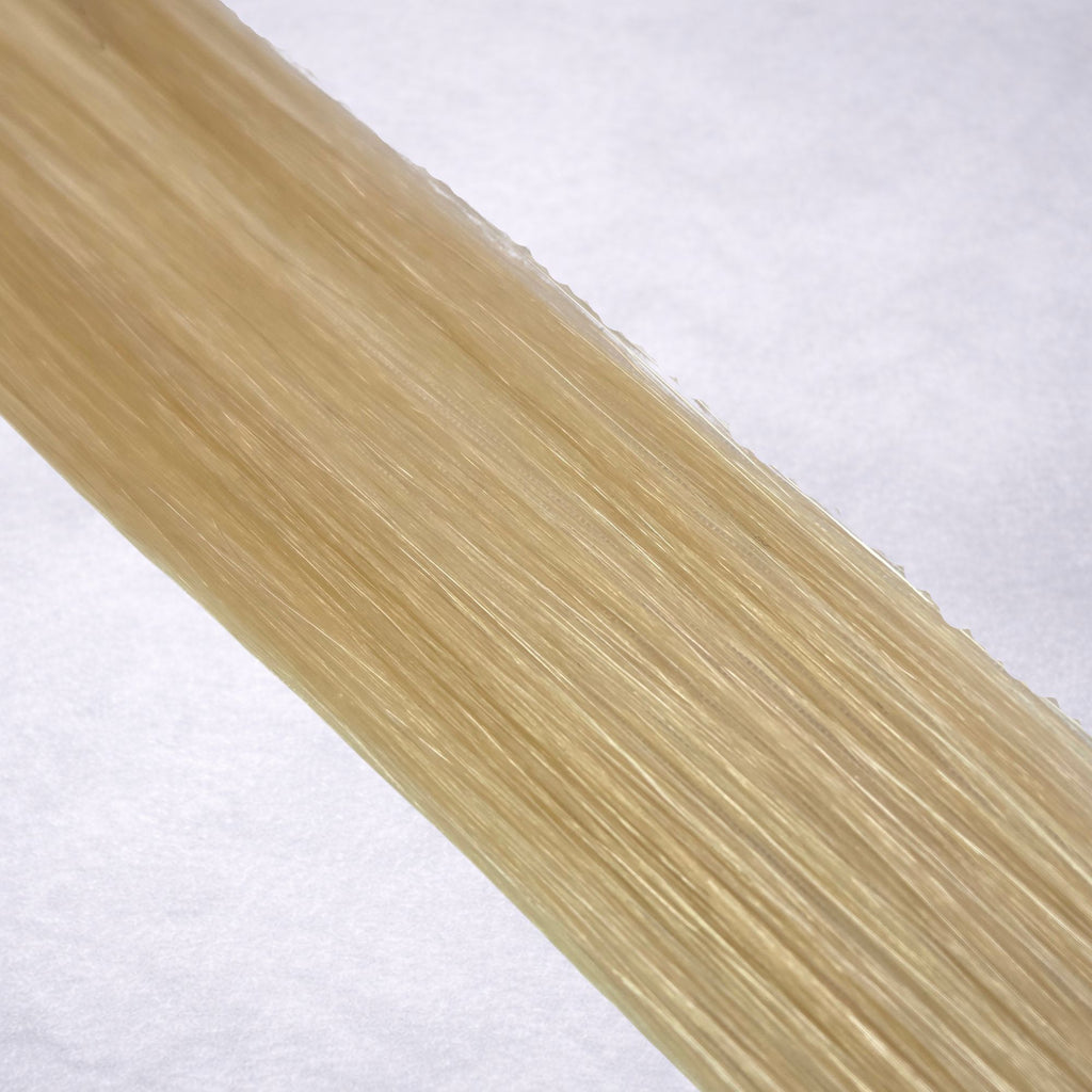 Luxury Remy human hair extension shade swatch in Honey #22 from the Remalisse Studio Collection, featuring a warm blonde tone with soft golden undertones, natural dimension, a silky finish, and natural shine.
