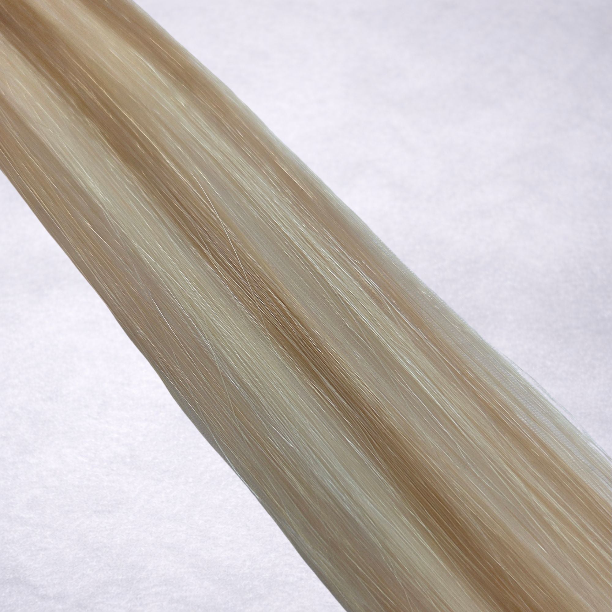 Studio Collection shade swatch in LA Blonde #P16A/60A, featuring a dimensional blend of cool Scandi Blonde and light Oatmilk blonde tones with bright creamy ribboned highlights, a silky finish, and natural shine.