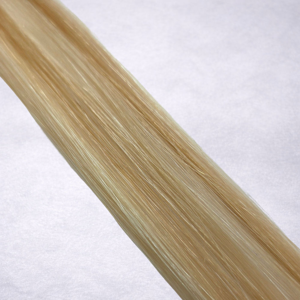 Studio Collection shade swatch in Malibu Blonde #P18/60, featuring a dimensional blend of warm Wheat blonde and creamy Vanilla blonde tones with sunlit golden ribboned highlights, a silky finish, and natural shine.