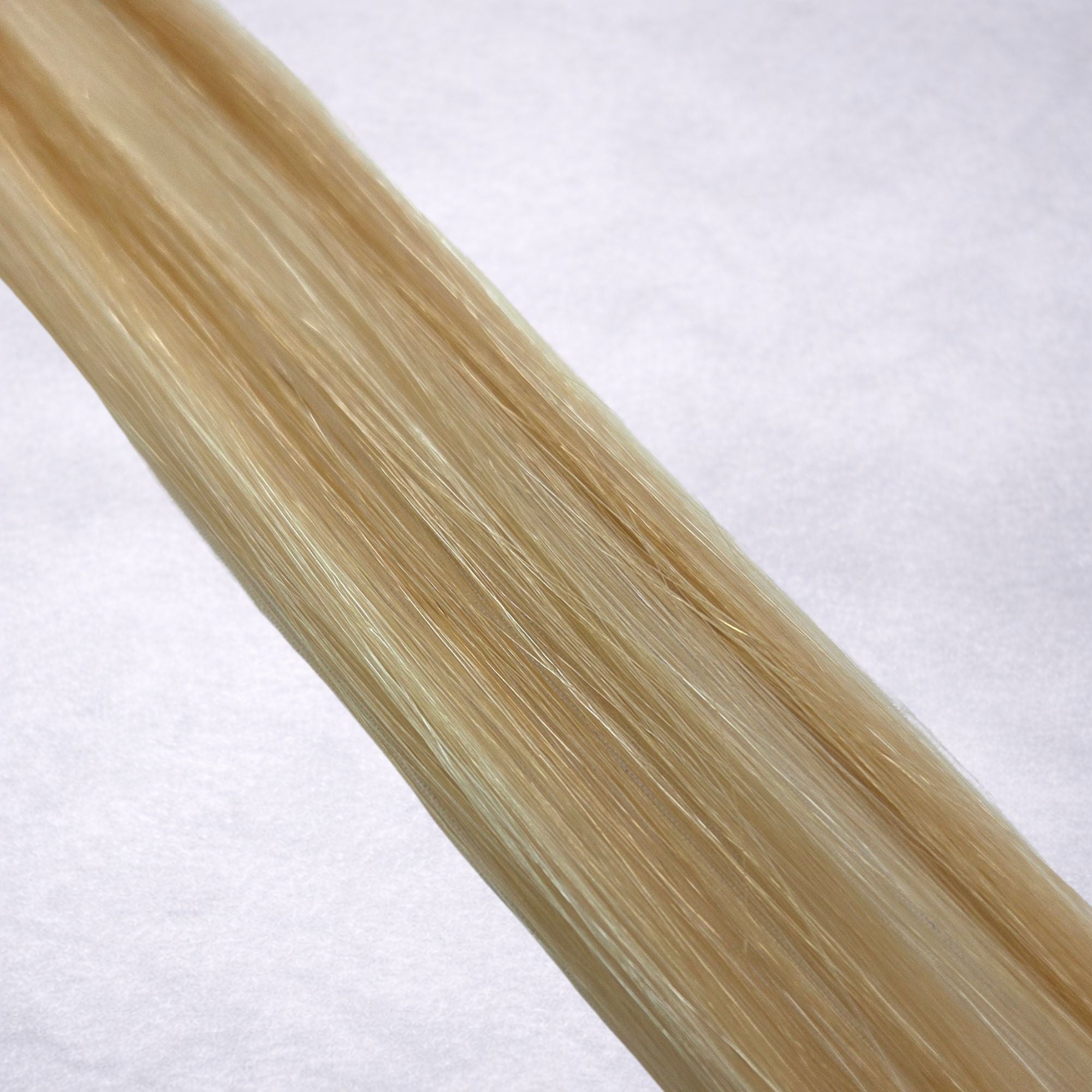 Studio Collection shade swatch in Malibu Blonde #P18/60, featuring a dimensional blend of warm Wheat blonde and creamy Vanilla blonde tones with sunlit golden ribboned highlights, a silky finish, and natural shine.
