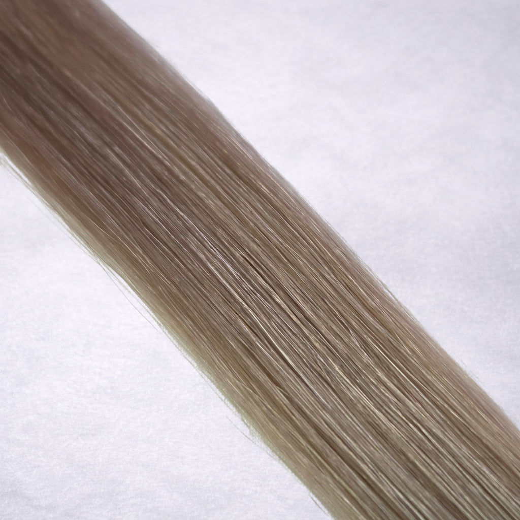 Luxury Remy human hair extension shade swatch in Mink #18A from the Remalisse Studio Collection, featuring a cool ash blonde tone with smoky taupe undertones, soft dimension, a silky finish, and natural shine.