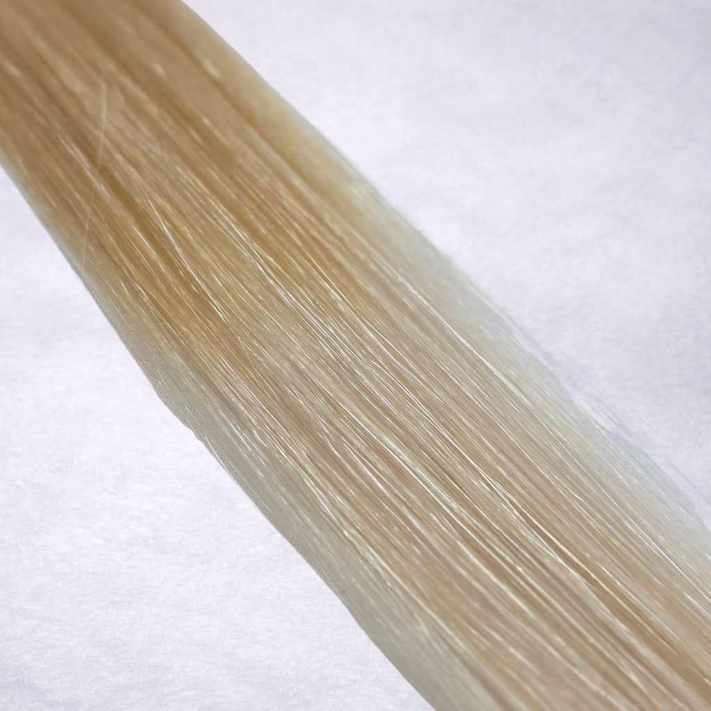 Studio Collection shade swatch in Oatmilk Melt #T18/60A, featuring a dimensional blend of soft wheat blonde roots melting into cool oatmilk blonde lengths with creamy ash tones, a silky finish, and natural shine.