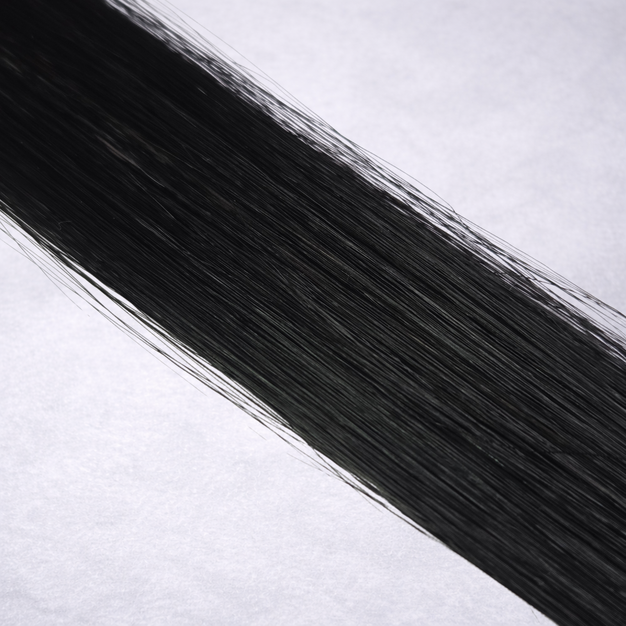 Luxury Remy human hair extension shade swatch in Obsidian #1, featuring a rich true black tone with a smooth silky finish and natural shine.
