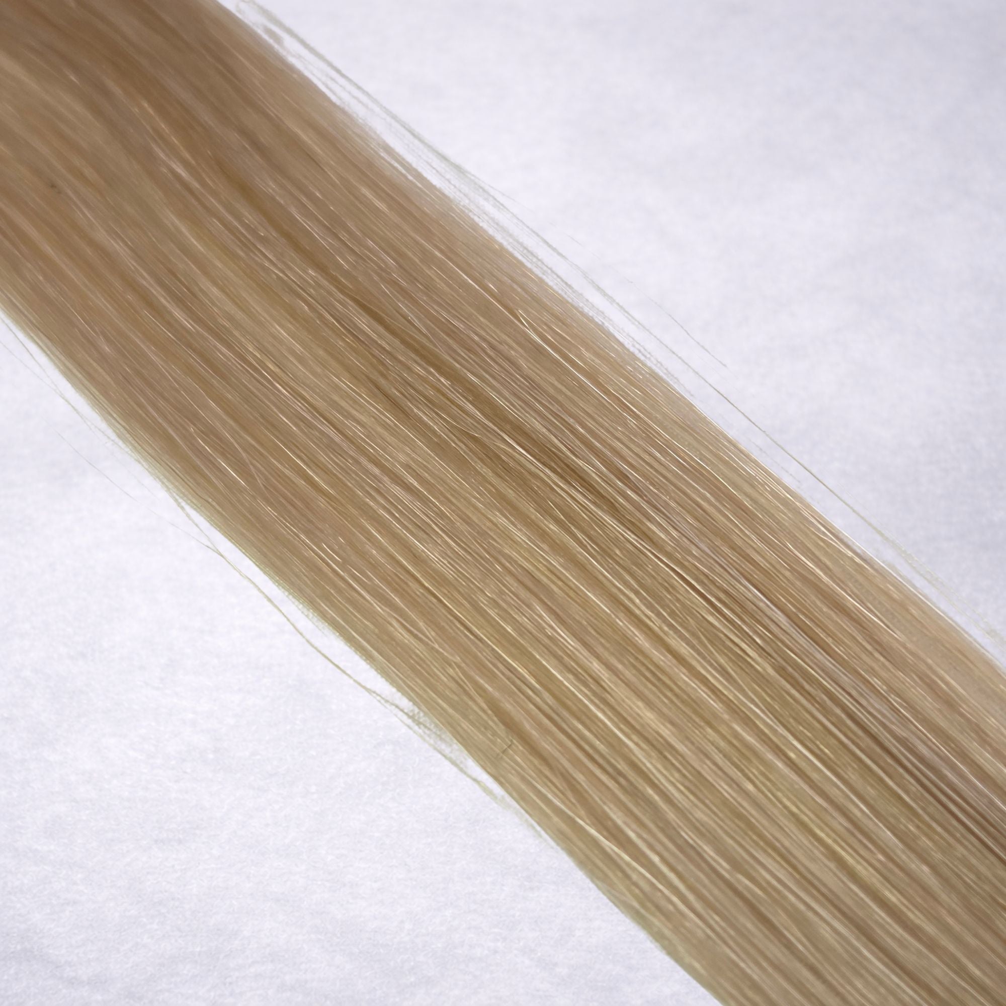 Luxury Remy human hair extension shade swatch in Scandi Blonde #16A from the Remalisse Studio Collection, featuring a cool light blonde tone with soft ash undertones, subtle dimension, a silky finish, and natural shine.

