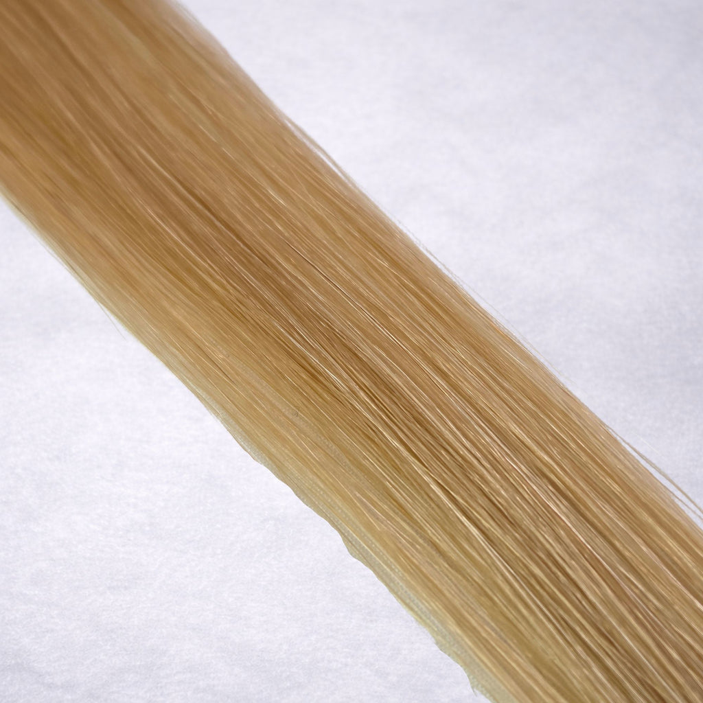 Luxury Remy human hair extension shade swatch in Soft Gold #16 from the Remalisse Studio Collection, featuring a warm blonde tone with soft golden undertones, natural dimension, a silky finish, and natural shine.