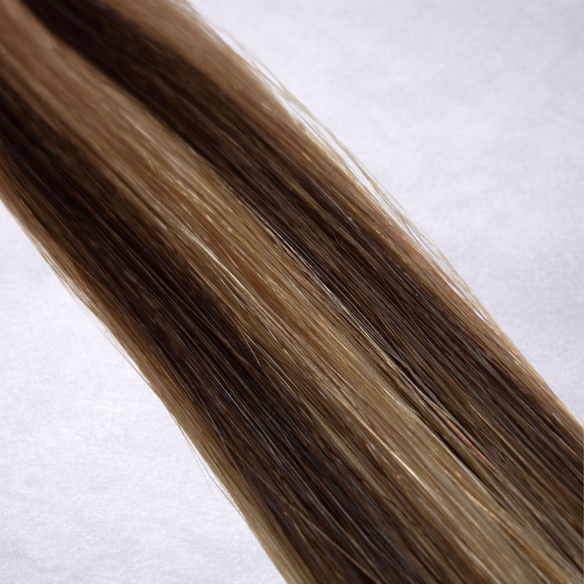 Studio Collection shade swatch in Truffle Waves #P4/10, featuring a dimensional blend of rich chocolate brunette and soft petal blonde tones with cool truffle-inspired ribboned highlights, a silky finish, and natural shine.