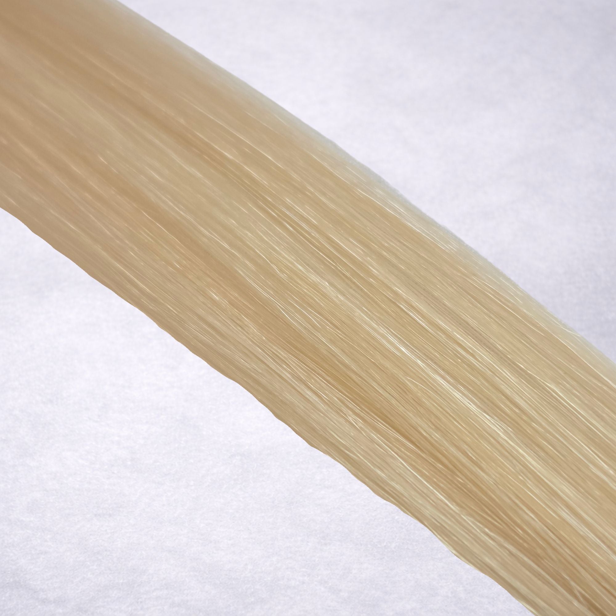 Luxury Remy human hair extension shade swatch in Vanilla #60 from the Remalisse Studio Collection, featuring a light creamy blonde tone with soft neutral undertones, subtle dimension, a silky finish, and natural shine.