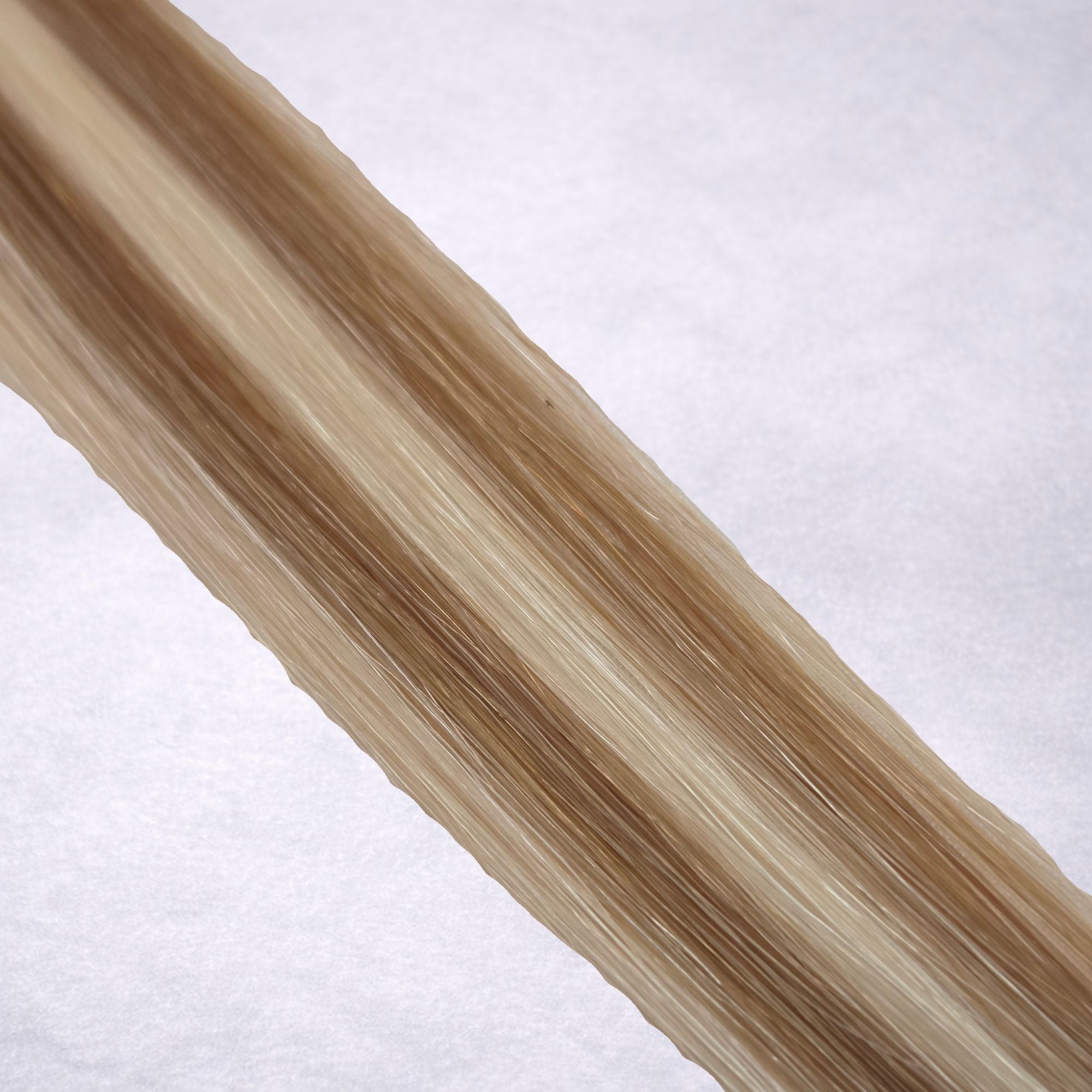 Studio Collection shade swatch in Vanilla Latte #P10/60A, featuring a dimensional blend of soft petal blonde and cool oatmilk blonde tones with creamy ribboned highlights, a silky finish, and natural shine.