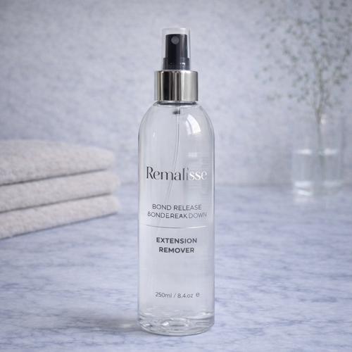 Remalisse Bond Release and Breakdown hair extension remover bottle on marble bathroom background.