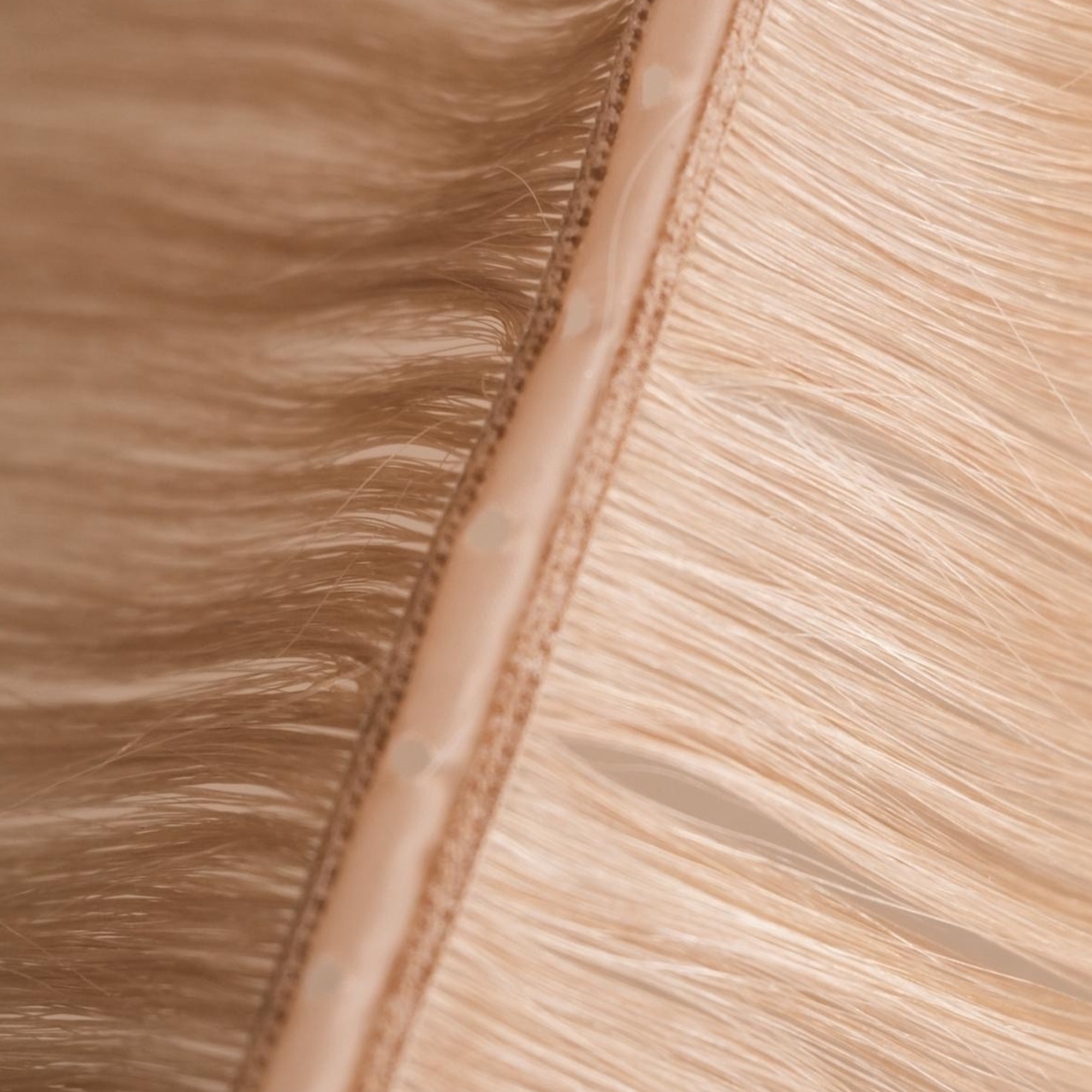 Close-up detail of a Remalisse Studio Butterfly Weft hair extension showing the ultra-thin PU centre, stitched invisible weft construction and seamless blonde Remy hair designed for discreet, lightweight installations
