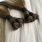 Studio hand tied weft hair extension bundles displayed on blonde hair extensions background