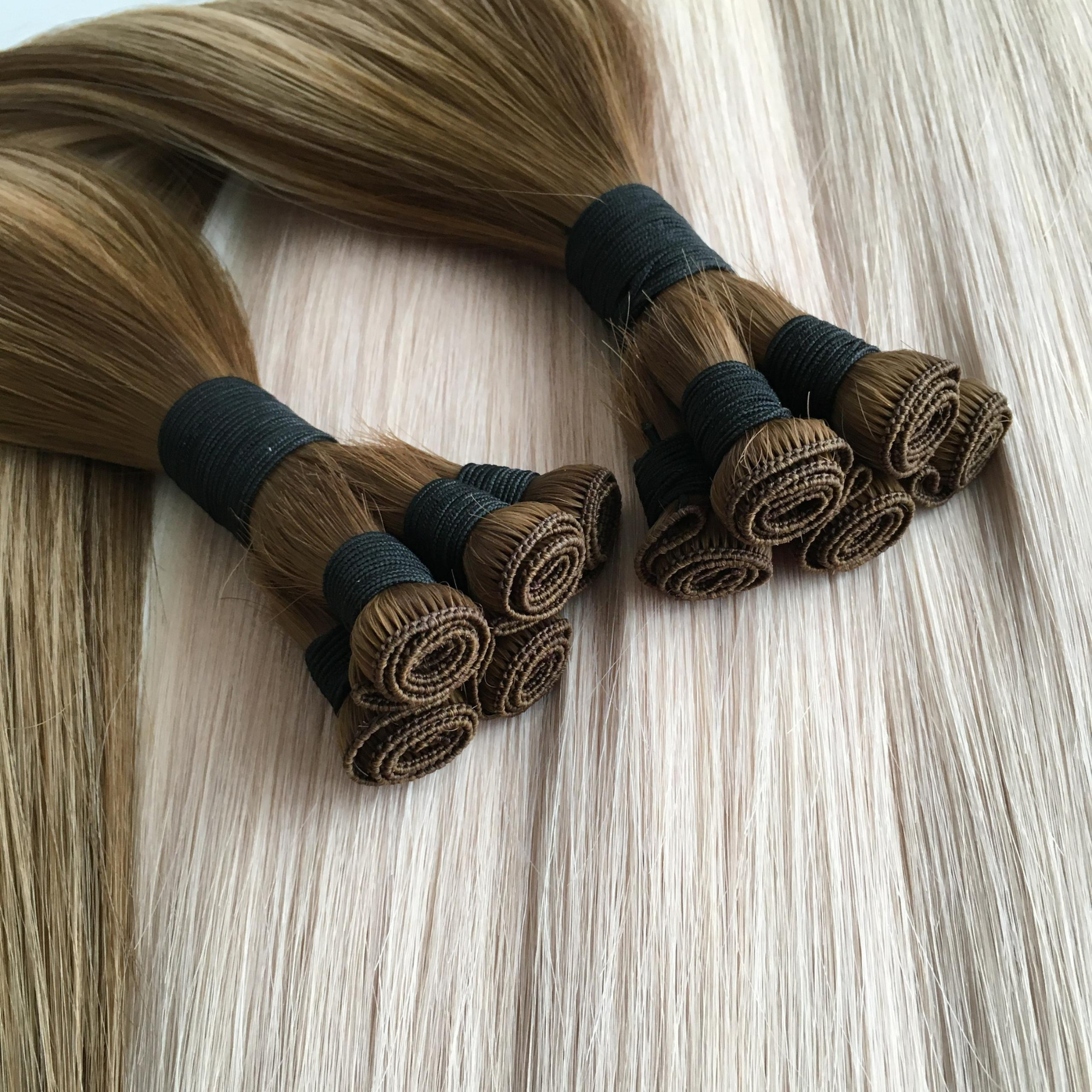 Studio hand tied weft hair extension bundles displayed on blonde hair extensions background
