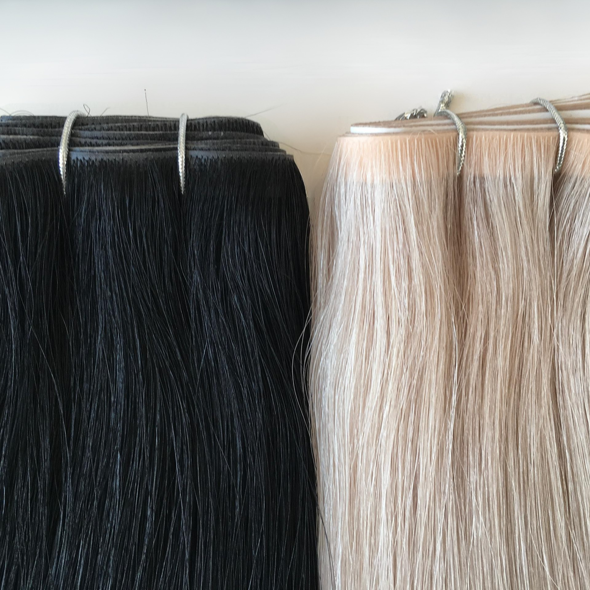Close-up comparison of a dark brunette and platinum blonde invisible tape weft hair extensions displayed side by side. The Remy human hair showcases smooth texture, ultra-flat tape weft construction and a sleek glossy finish against a clean white background.