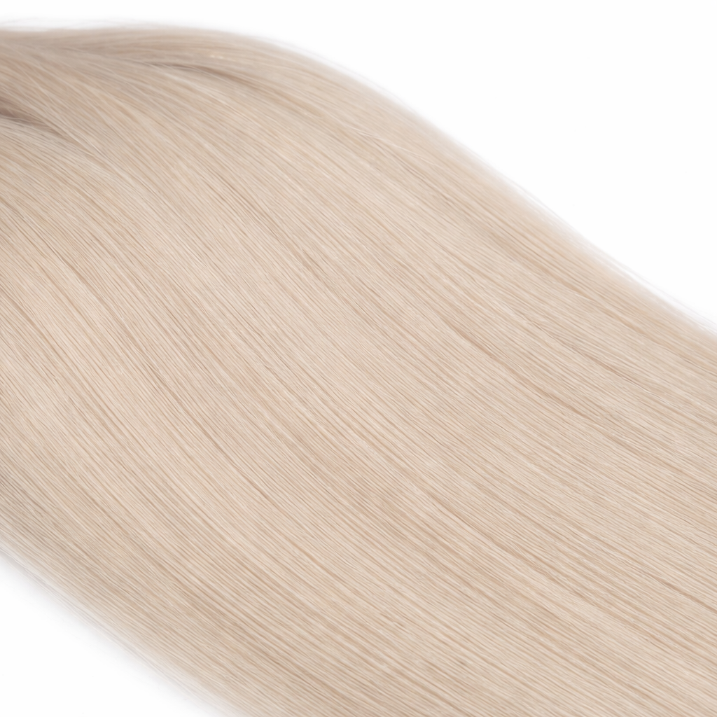 Close-up of silky straight keratin tip blonde hair extensions showing smooth texture and natural shine on a plain white background.