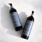 Remalisse Smooth Silk Conditioner and Deep Cleanse Shampoo bottles photographed on white background with natural sunlight shadow. 