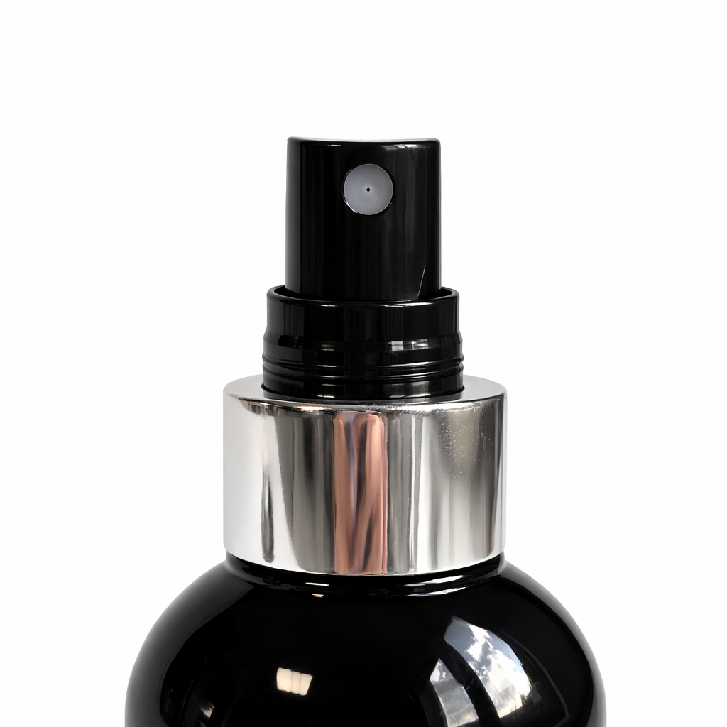 Close-up of a black spray bottle nozzle with silver collar on a Remalisse haircare product against a plain white background. 