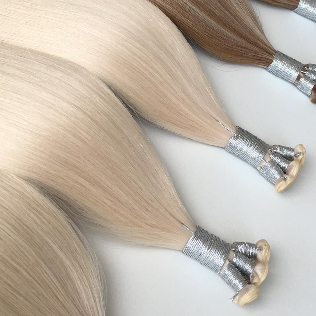 Blonde studio genius weft hair extensions bundles with silver wraps on a clean white background