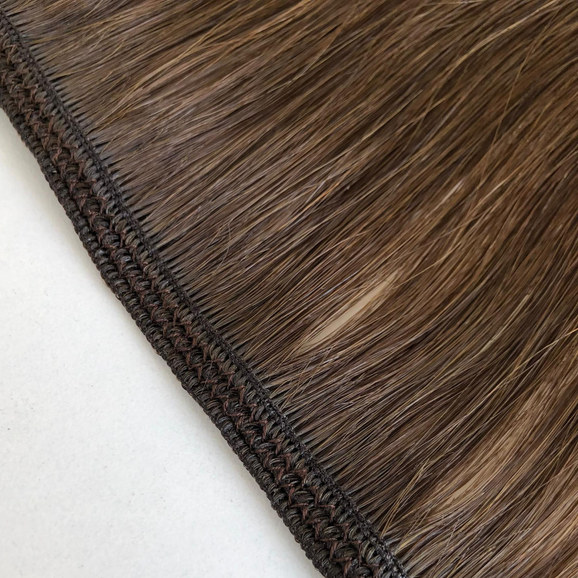 Close-up of the underside of a Remalisse volume weft hair extension showing the three sewn wefts combined together, highlighting the stitched construction, secure seam and flexible base that sits against the scalp in a brunette shade. 