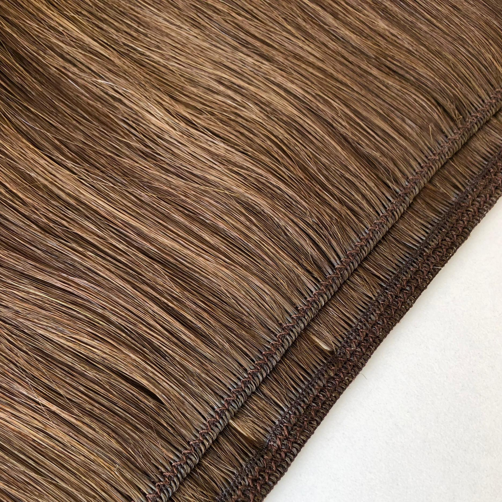 Close-up comparison of a Remalisse volume weft hair extension showing both the underside and outer side of the weft construction, highlighting the stitched seam, hair density and flexible weft design in a brunette shade.