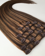 Studio Collection Remy human hair clip-in extensions in dimensional brunette balayage shades, featuring discreet multi-piece clip wefts with seamless lightweight construction, soft silky texture and natural shine.