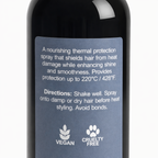 Close-p of the back label on Remalisse heat guard spray bottle showing product description, directions for use, and vegan and cruelty-free icons. 